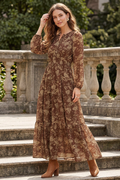 Woman wearing a long earthy brown floral maxi dress with pockets on an outdoor background